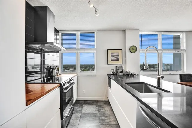a view of a kitchen with kitchen island a large counter top space a sink and living room view