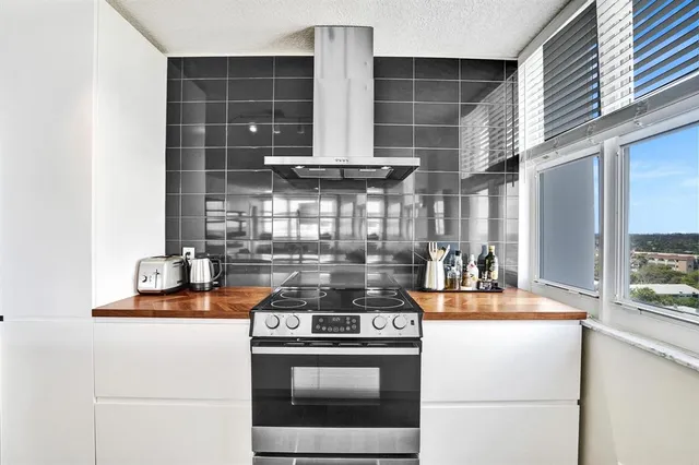 a kitchen with stainless steel appliances granite countertop a refrigerator a stove and a sink