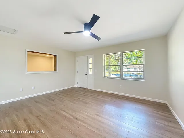 a view of a hallway with wooden floor and front door