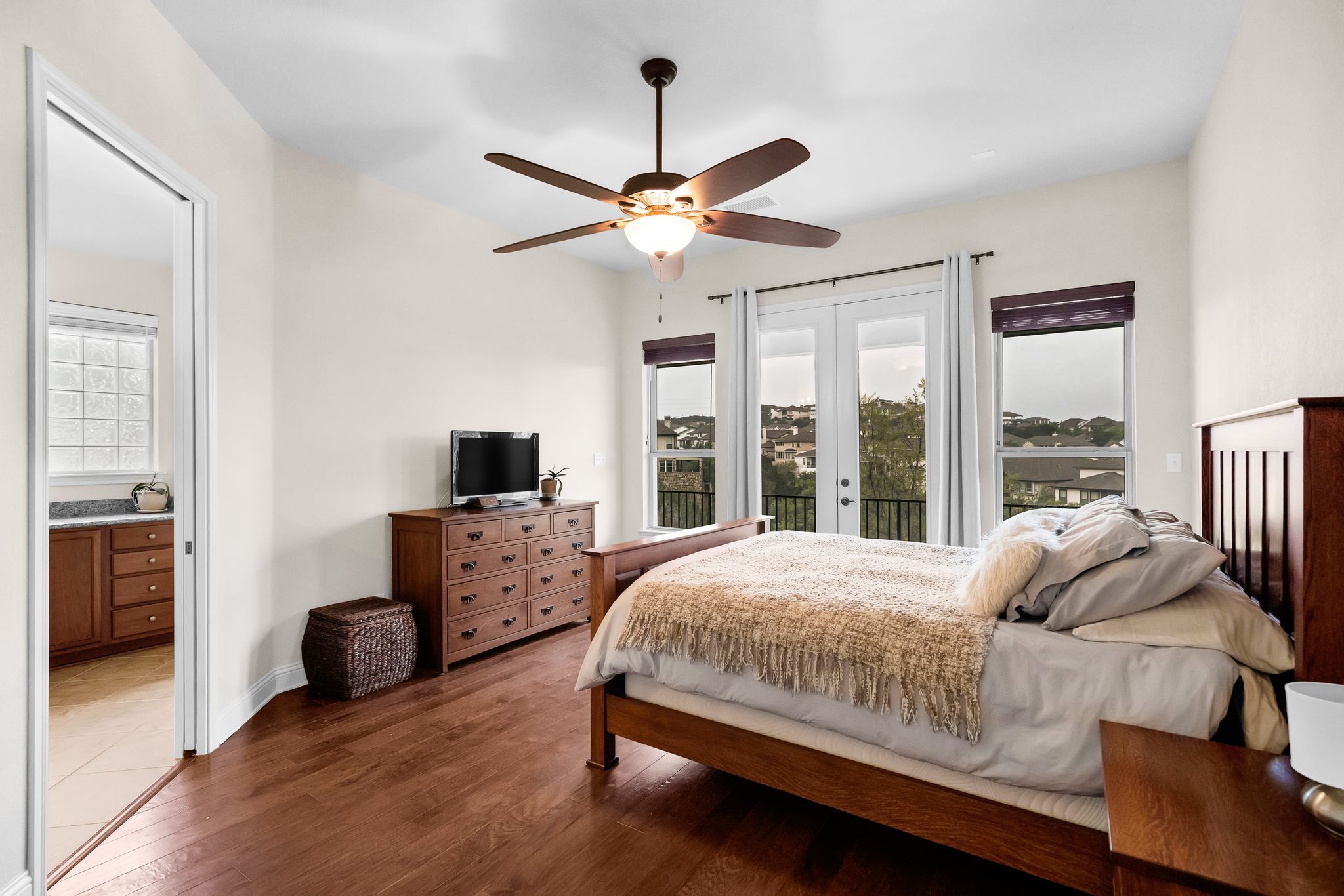 212 Tavish Trail Austin, TX 78738 - Photo 20 of 32 a bedroom with a bed and a chandelier