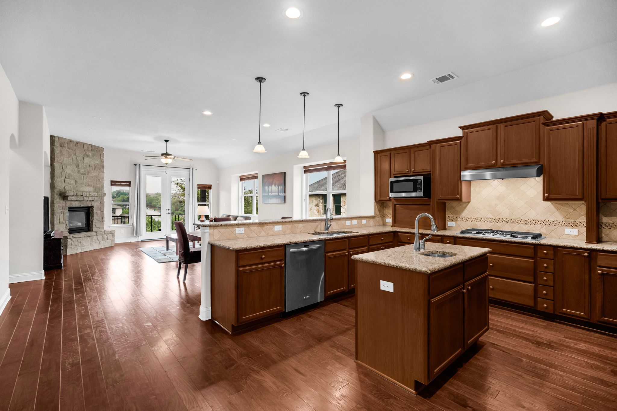 212 Tavish Trail Austin, TX 78738 - Photo 6 of 32 a kitchen with stainless steel appliances granite countertop wooden floors and sink