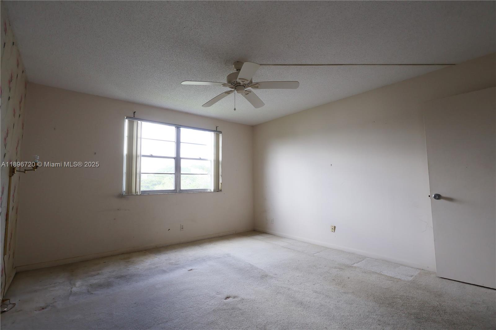 1705 Andros Isle, Unit E3 Coconut Creek, FL 33066 - Photo 11 of 17 an empty room with a window and a ceiling fan
