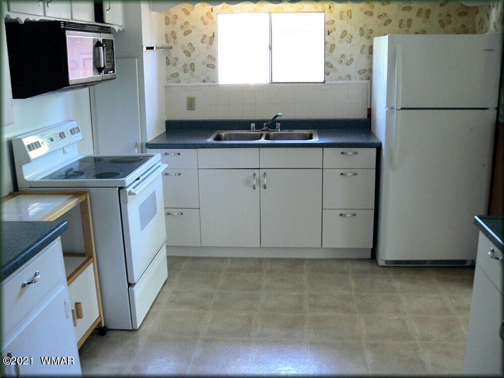 2179 Chevelon Road Overgaard, AZ 85933 - Photo 7 of 11 a kitchen with a sink stove and refrigerator