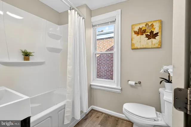 a white toilet sitting next to a bathroom sink and tub