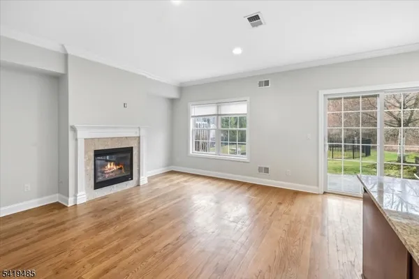 a view of empty room with wooden floor and fireplace