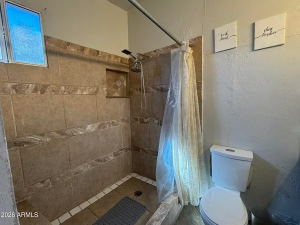 a bathroom with a toilet and a shower