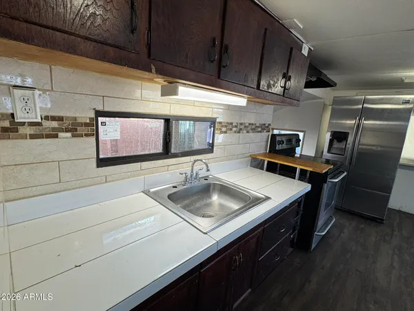 a kitchen with stainless steel appliances granite countertop a sink stove and cabinets