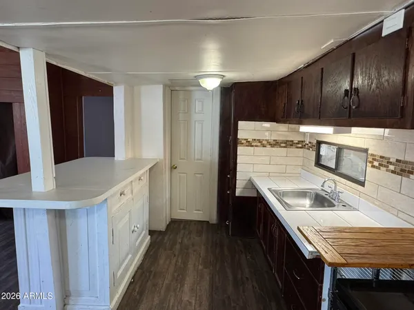 a kitchen with granite countertop a sink a stove refrigerator and cabinets