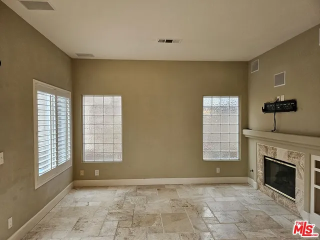 a view of an empty room with a fireplace and a window