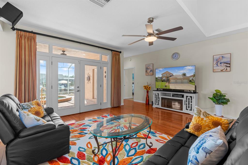 830 Golf Island Drive Apollo Beach, FL 33572 - Photo 25 of 87 a living room with furniture a flat screen tv and a floor to ceiling window