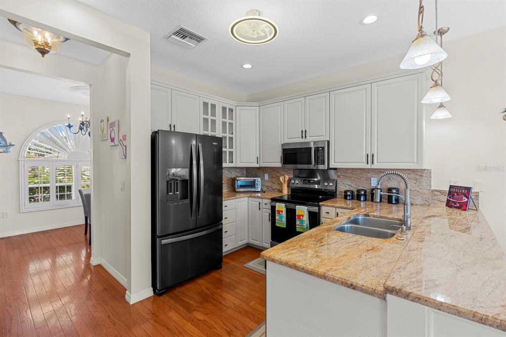 830 Golf Island Drive Apollo Beach, FL 33572 - Photo 31 of 87 a kitchen with granite countertop stainless steel appliances a refrigerator microwave and stove top oven