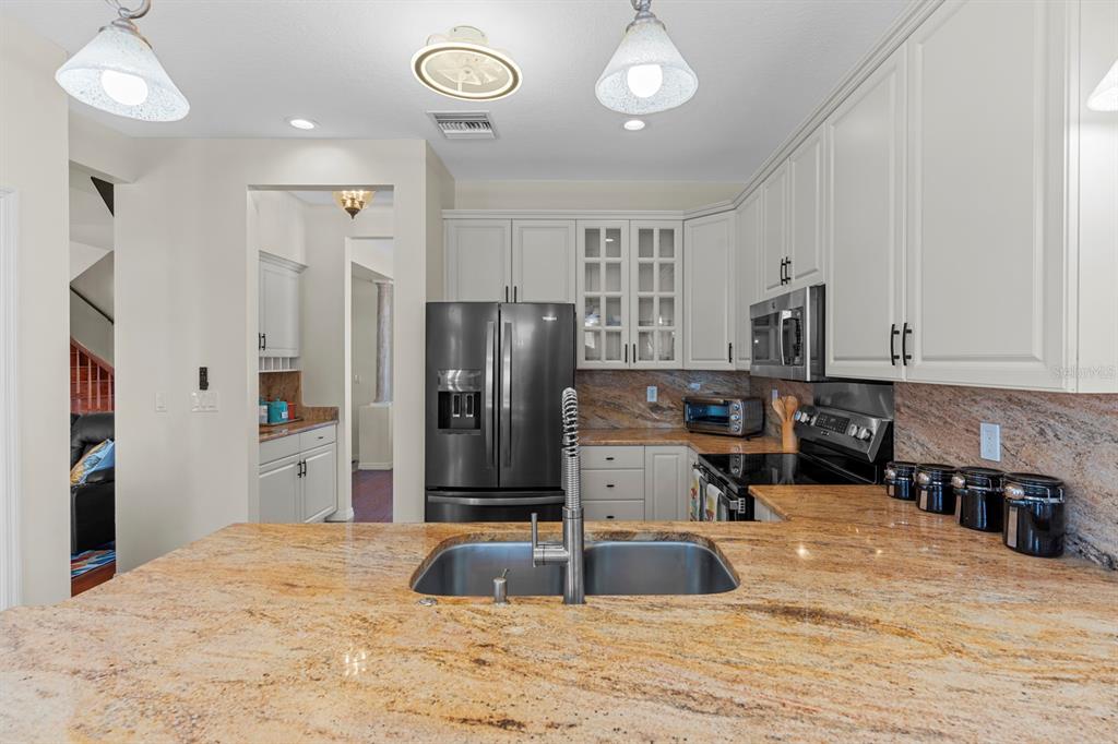 830 Golf Island Drive Apollo Beach, FL 33572 - Photo 32 of 87 a kitchen with stainless steel appliances a refrigerator sink and cabinets