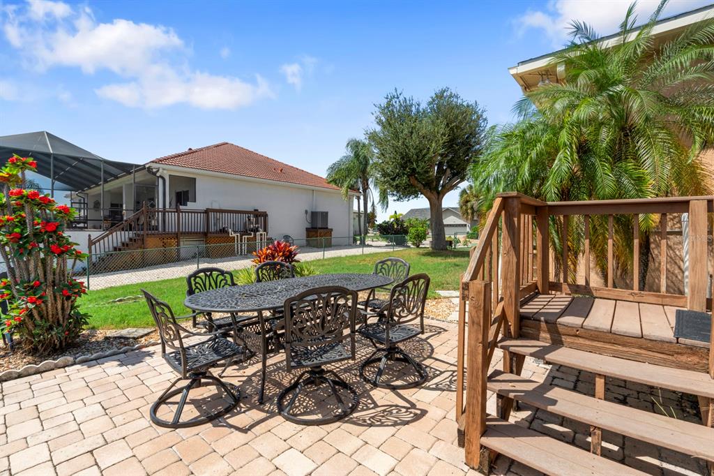 830 Golf Island Drive Apollo Beach, FL 33572 - Photo 78 of 87 a view of a patio with table and chairs potted plants and palm tree