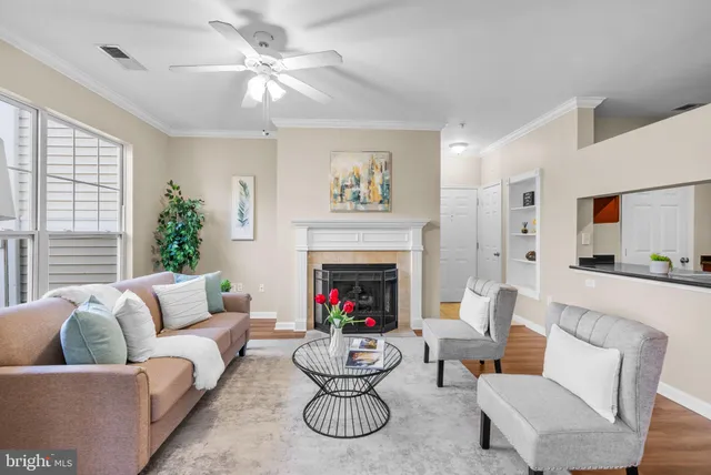 a living room with furniture a fireplace and a large window