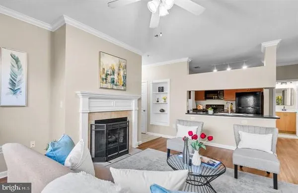 a living room with furniture a flat screen tv and kitchen view