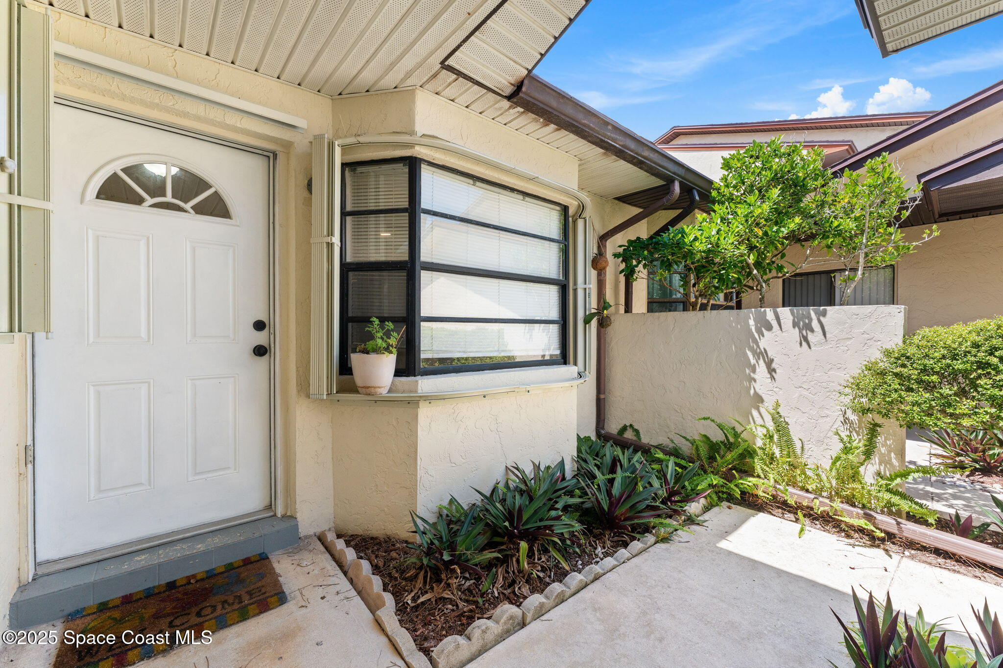 129 Seawind Drive, Unit 25 Satellite Beach, FL 32937 - Photo 1 of 28 a front view of a house with a yard