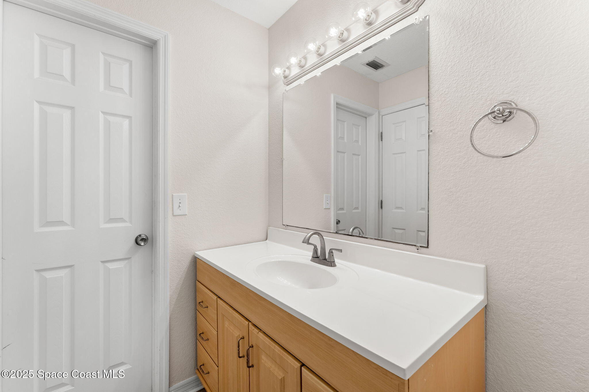 129 Seawind Drive, Unit 25 Satellite Beach, FL 32937 - Photo 13 of 28 a bathroom with a sink vanity and a mirror