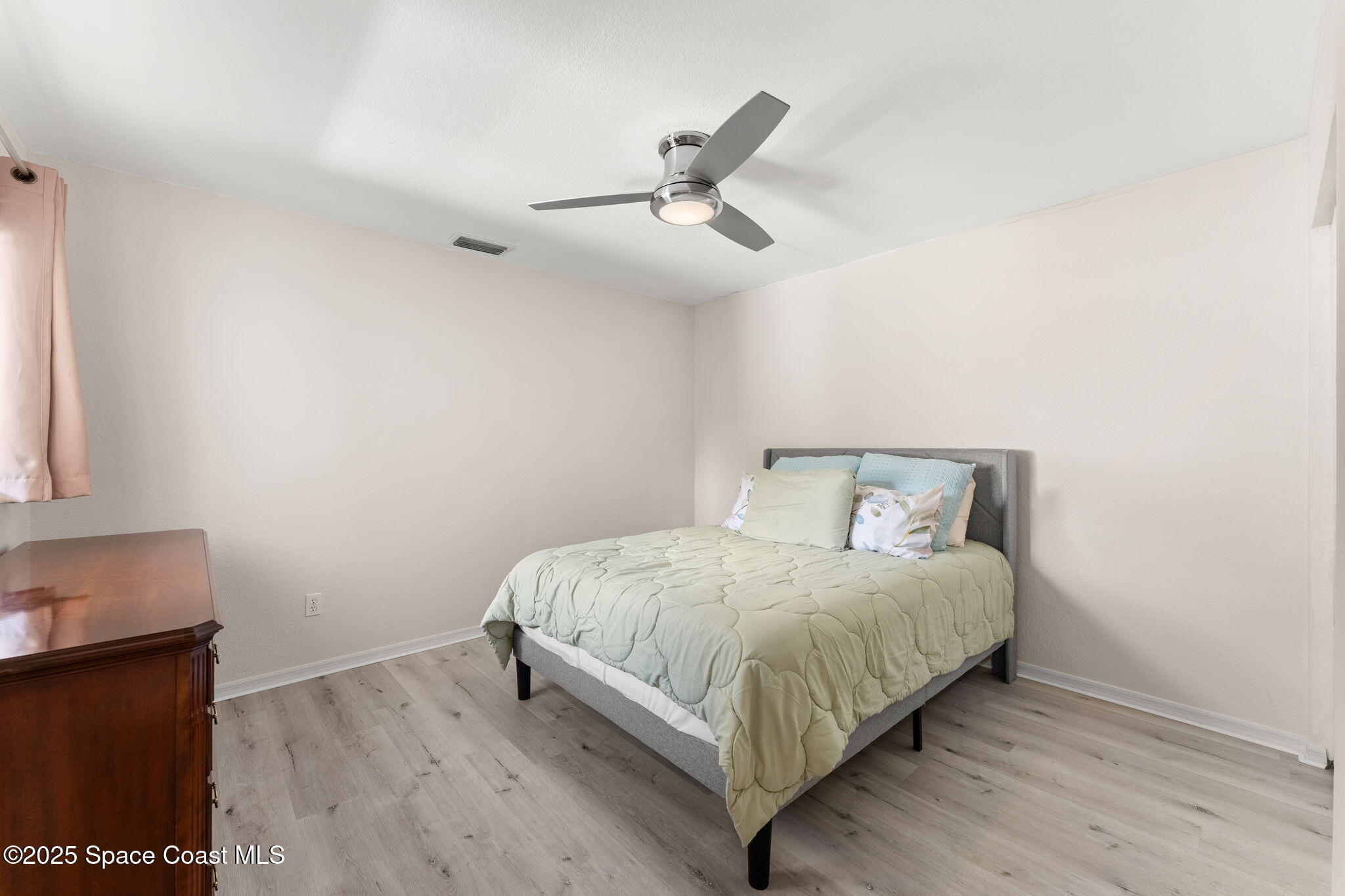 129 Seawind Drive, Unit 25 Satellite Beach, FL 32937 - Photo 14 of 28 a bedroom with a bed and a window