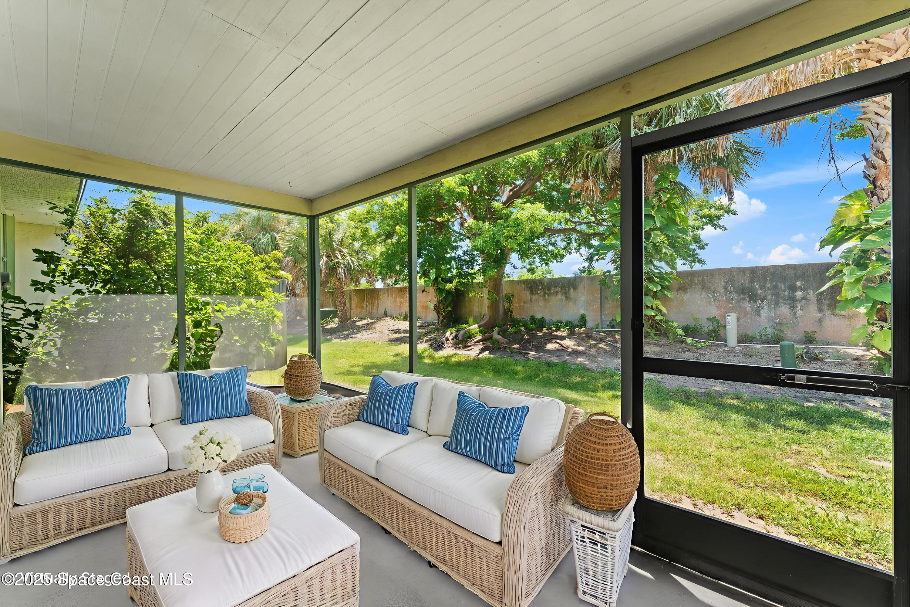 129 Seawind Drive, Unit 25 Satellite Beach, FL 32937 - Photo 16 of 28 a living room with large windows and a table