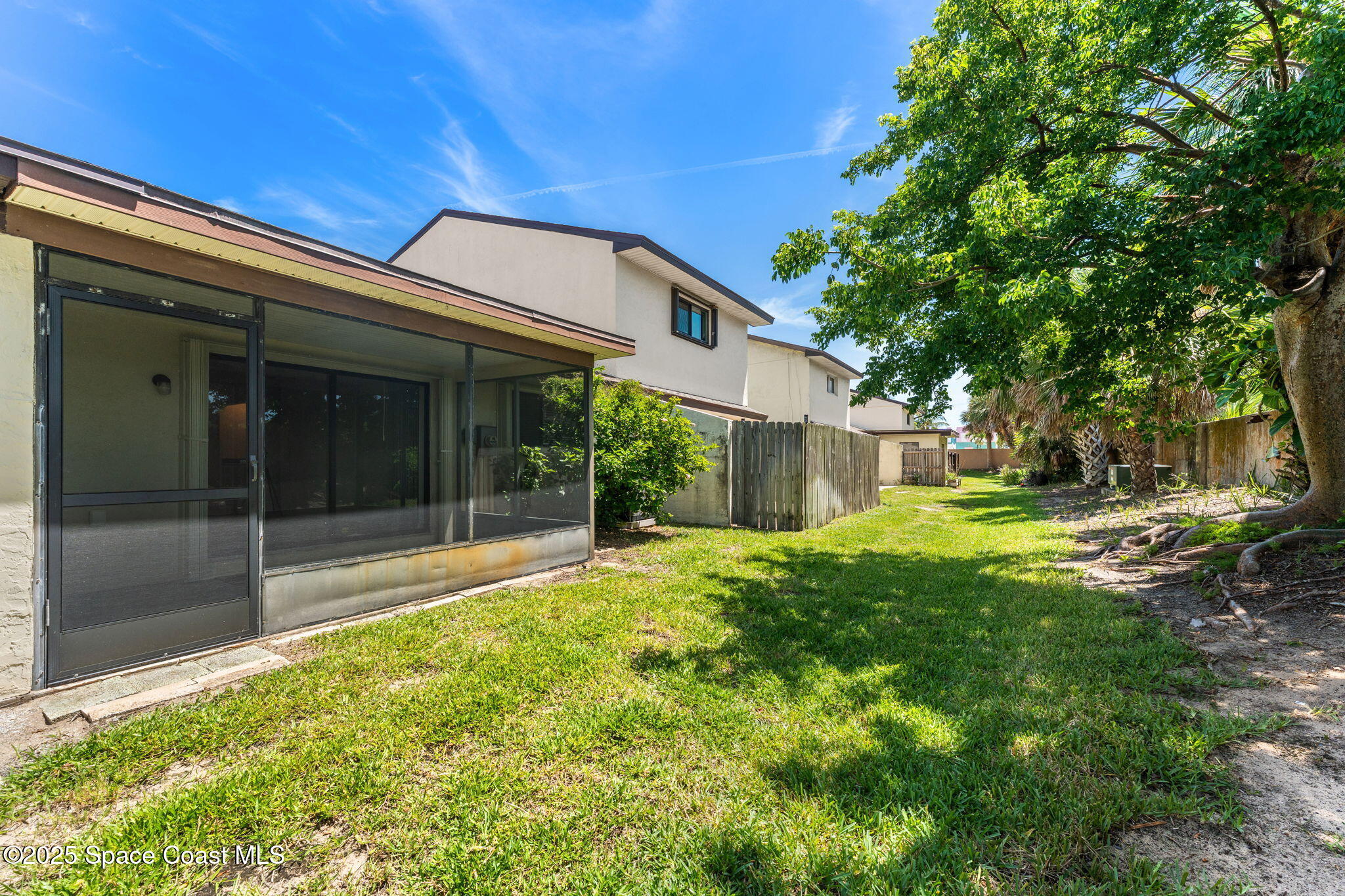 129 Seawind Drive, Unit 25 Satellite Beach, FL 32937 - Photo 18 of 28 a view of a house with backyard and a garden