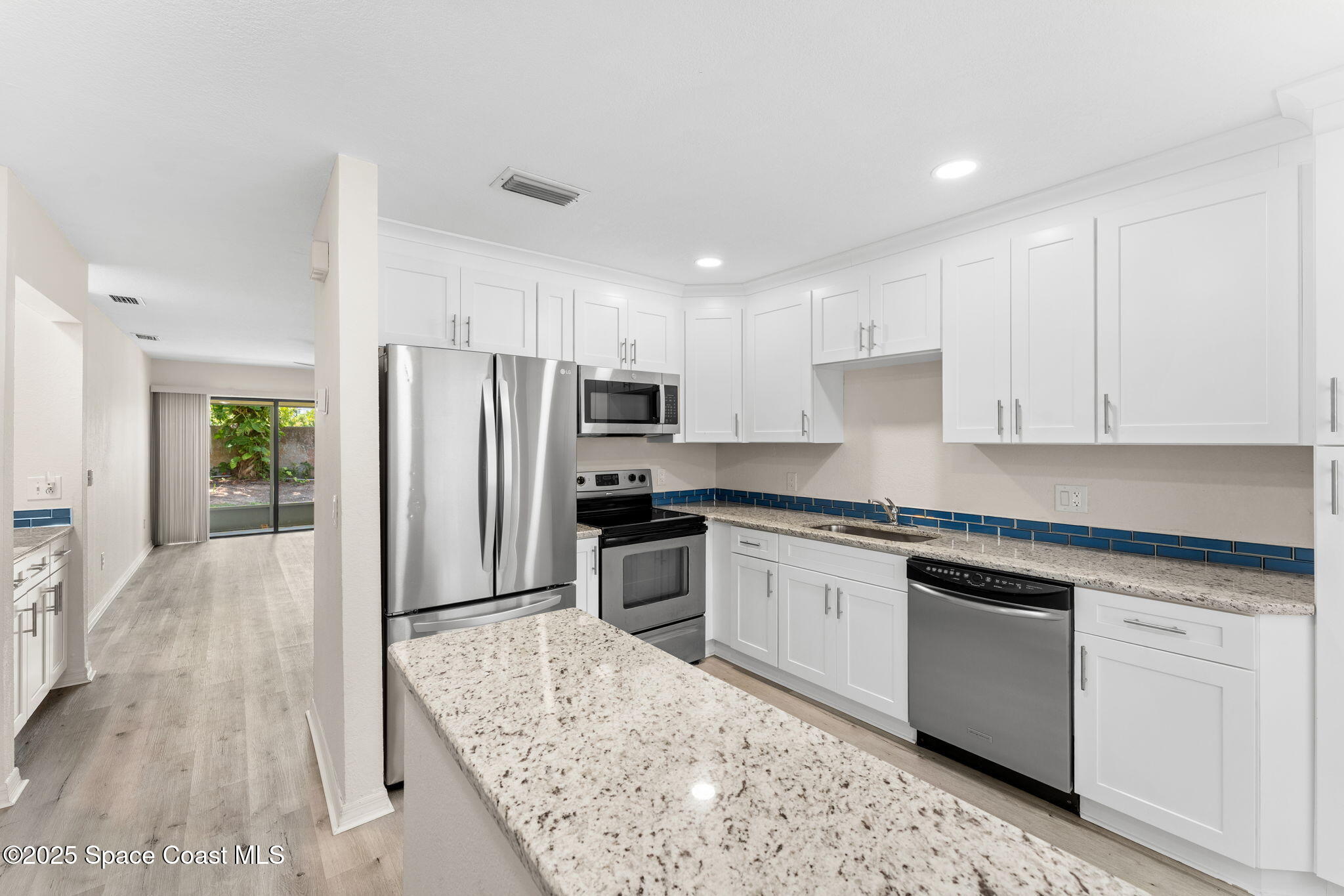 129 Seawind Drive, Unit 25 Satellite Beach, FL 32937 - Photo 6 of 28 a kitchen with granite countertop a refrigerator sink stove and oven