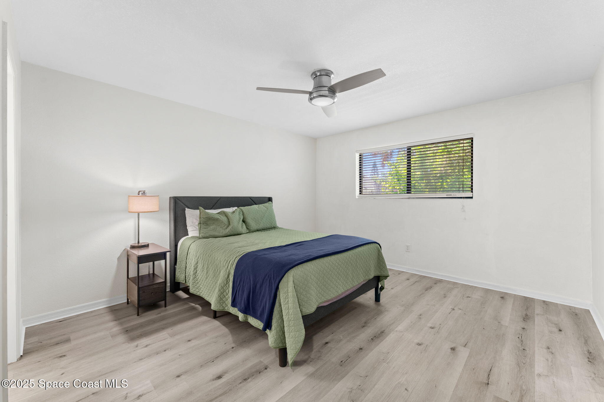 129 Seawind Drive, Unit 25 Satellite Beach, FL 32937 - Photo 9 of 28 a bed sitting in a bedroom next to a window