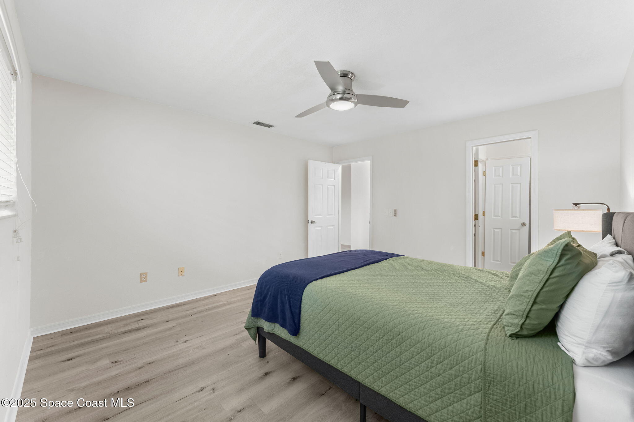 129 Seawind Drive, Unit 25 Satellite Beach, FL 32937 - Photo 10 of 28 a bedroom with a bed and a chandelier