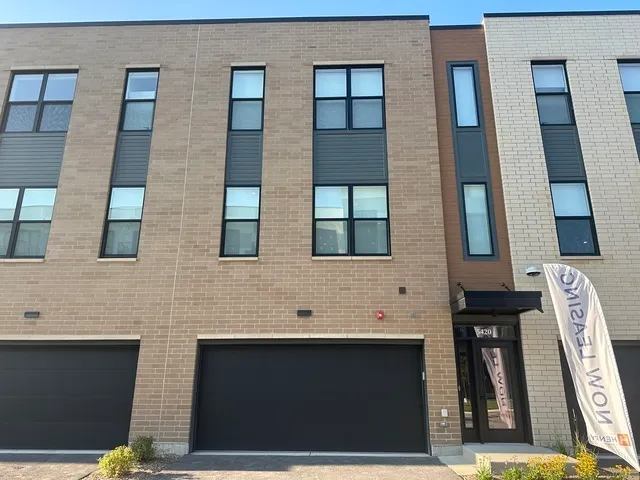 a living room with furniture a rug kitchen view and a large window