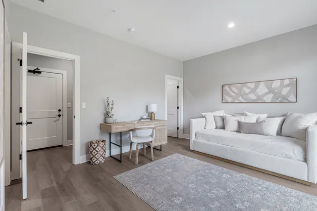 a living room with furniture and large windows