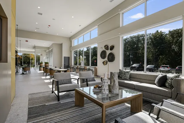a view of a dining room with furniture floor to ceiling window and floor to ceiling window