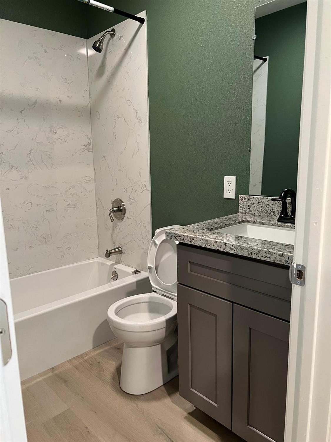 18393 Paradise Road Tracy, CA 95304 - Photo 29 of 36 a bathroom with a granite countertop sink toilet and shower