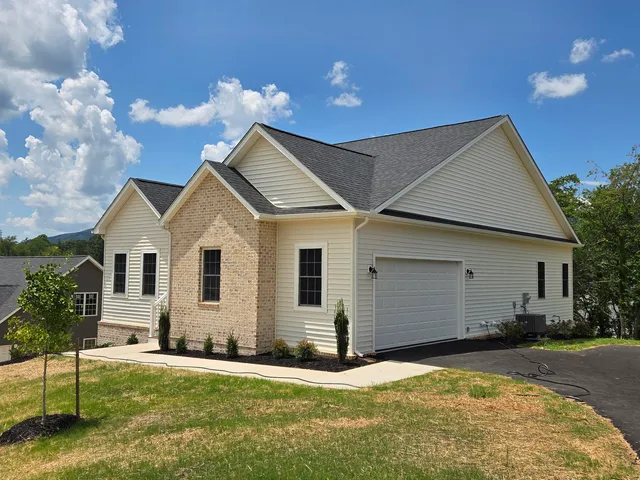a front view of house with yard and trees in the background