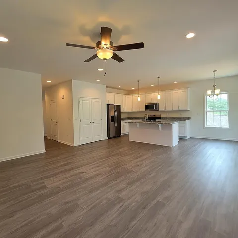 a kitchen with kitchen island granite countertop a sink and a stove