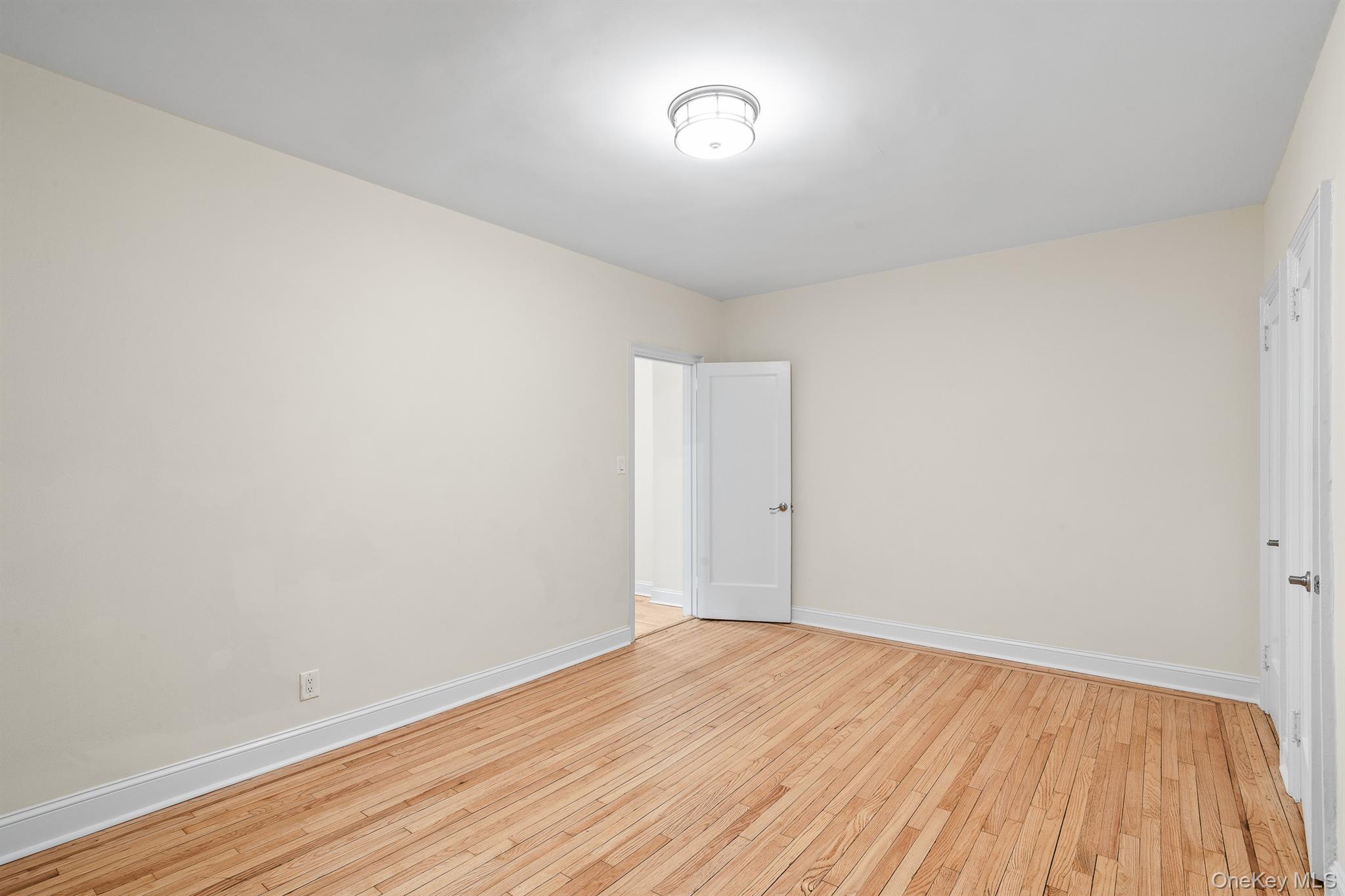 110-07 73rd Road, Unit 2K Queens, NY 11375 - Photo 15 of 17 a view of an empty room with wooden floor