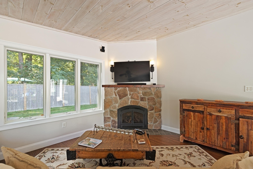 26 Cross Road Boxford, MA 01921 - Photo 16 of 41 a living room with furniture a flat screen tv and a fireplace