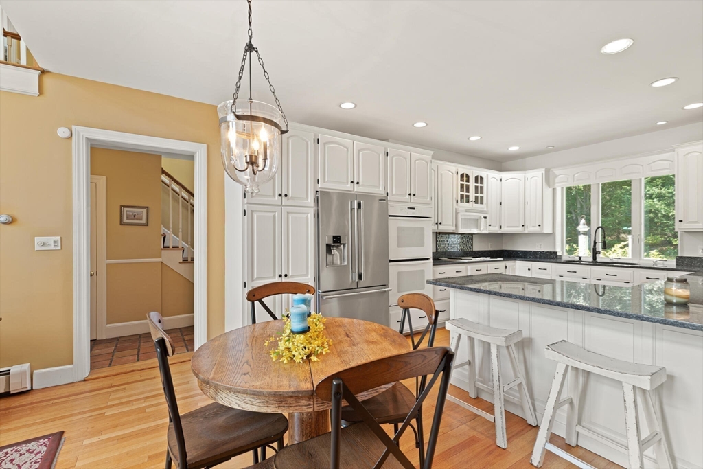 26 Cross Road Boxford, MA 01921 - Photo 8 of 41 a kitchen with stainless steel appliances granite countertop a dining table chairs and white cabinets