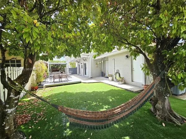 a view of a white house with a swimming pool and sitting area