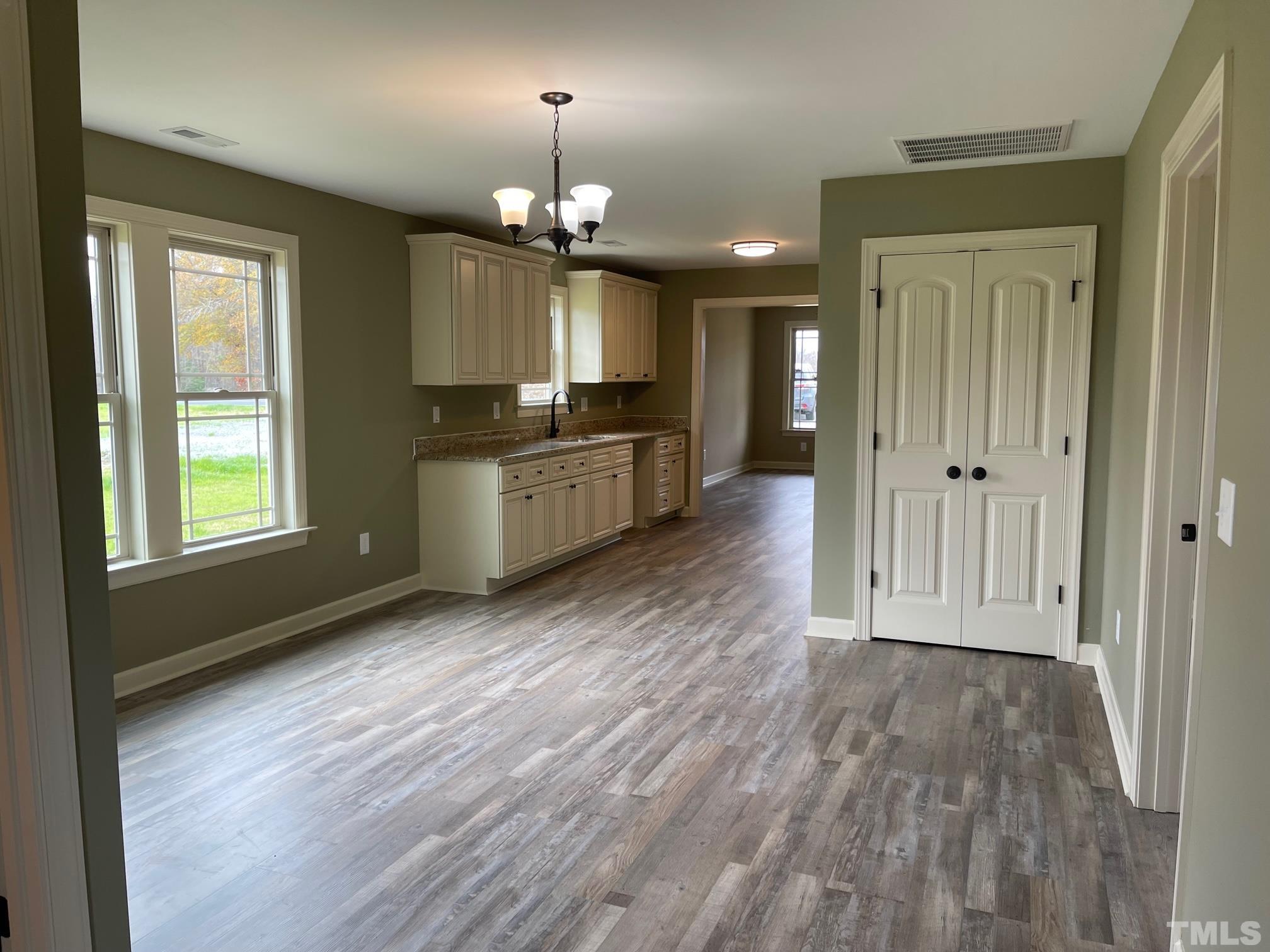 665 Bethel Church Road Angier, NC 27501 - Photo 11 of 32 an empty room with wooden floor front door and windows