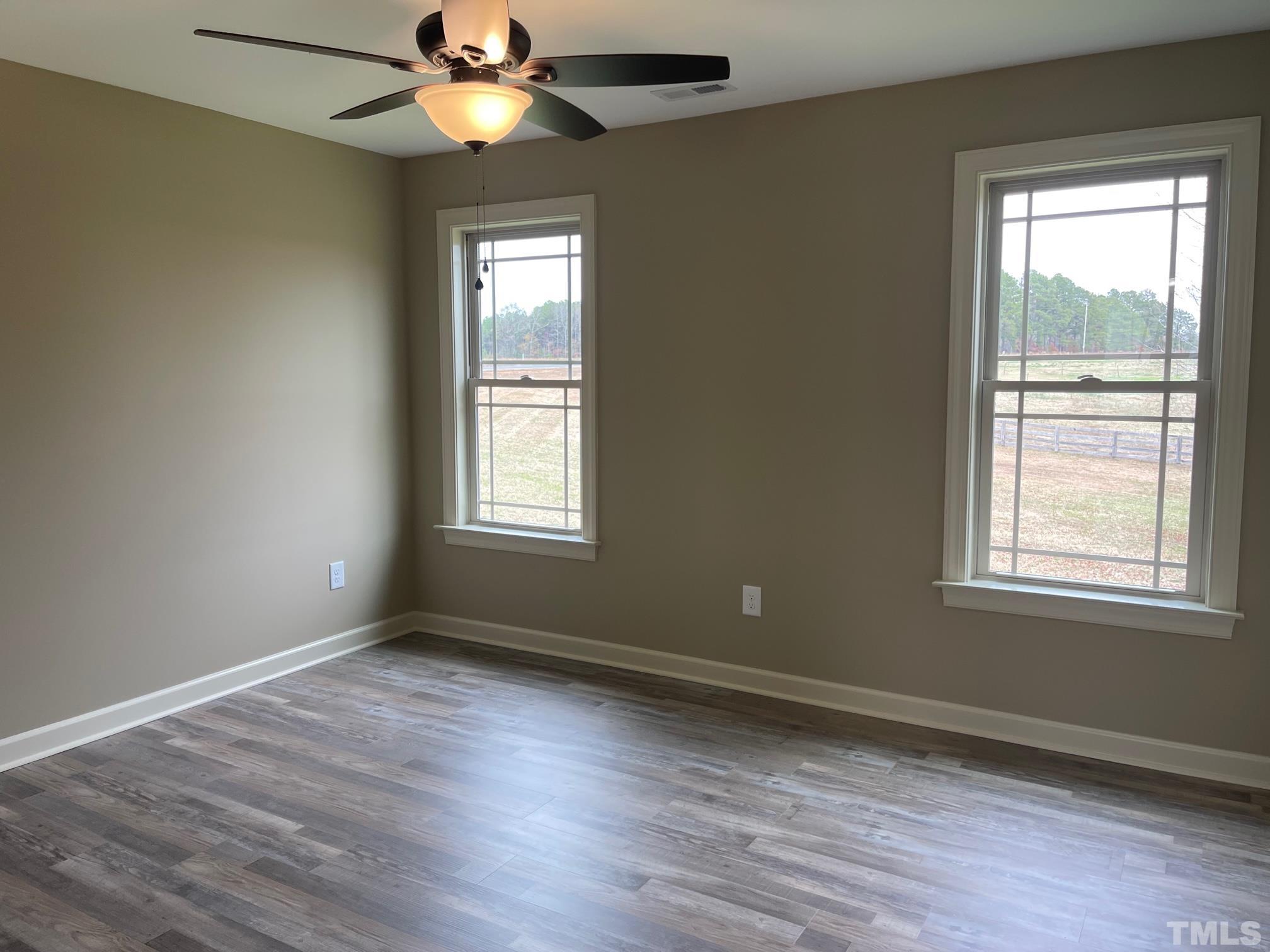 665 Bethel Church Road Angier, NC 27501 - Photo 16 of 32 a view of an empty room with wooden floor and a window