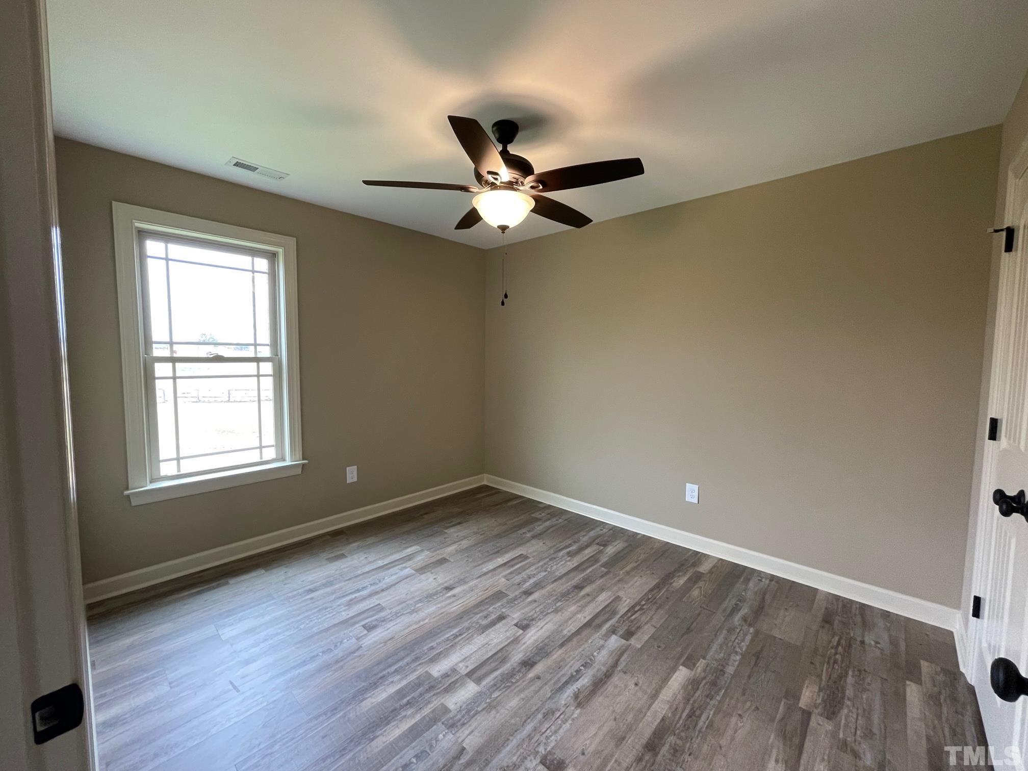665 Bethel Church Road Angier, NC 27501 - Photo 24 of 32 an empty room with wooden floor ceiling fan and window