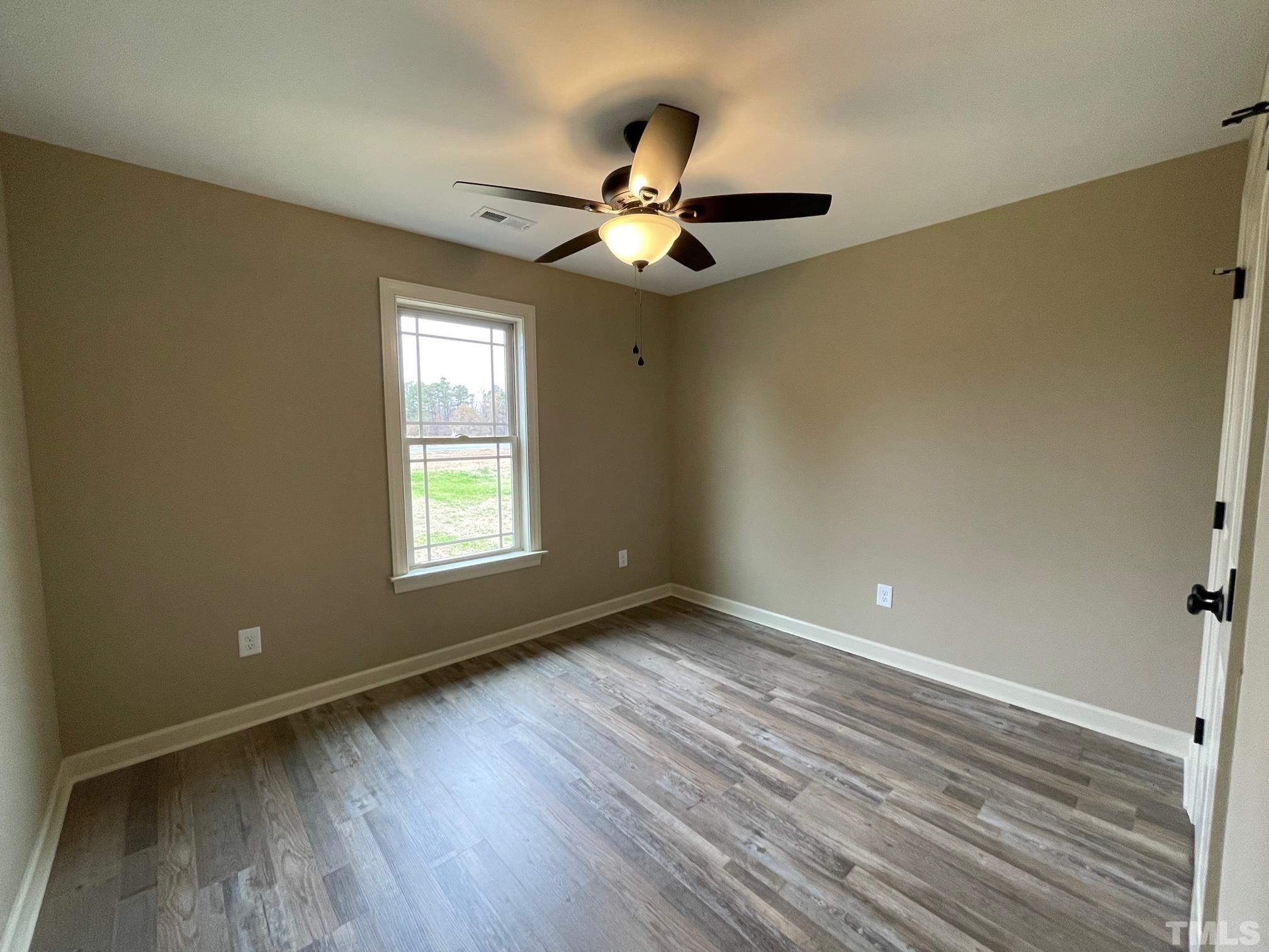 665 Bethel Church Road Angier, NC 27501 - Photo 29 of 32 a view of an empty room with window and wooden floor