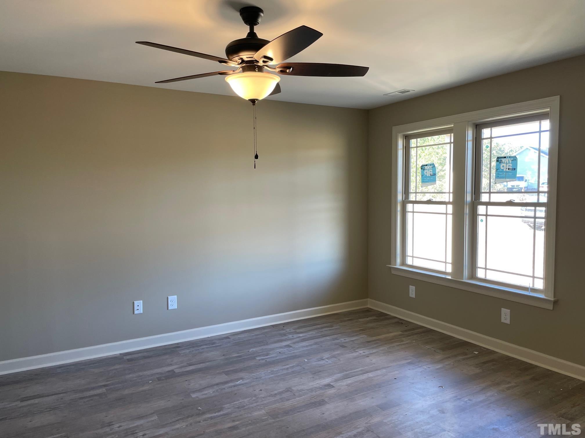 665 Bethel Church Road Angier, NC 27501 - Photo 3 of 32 an empty room with wooden floor fan and windows