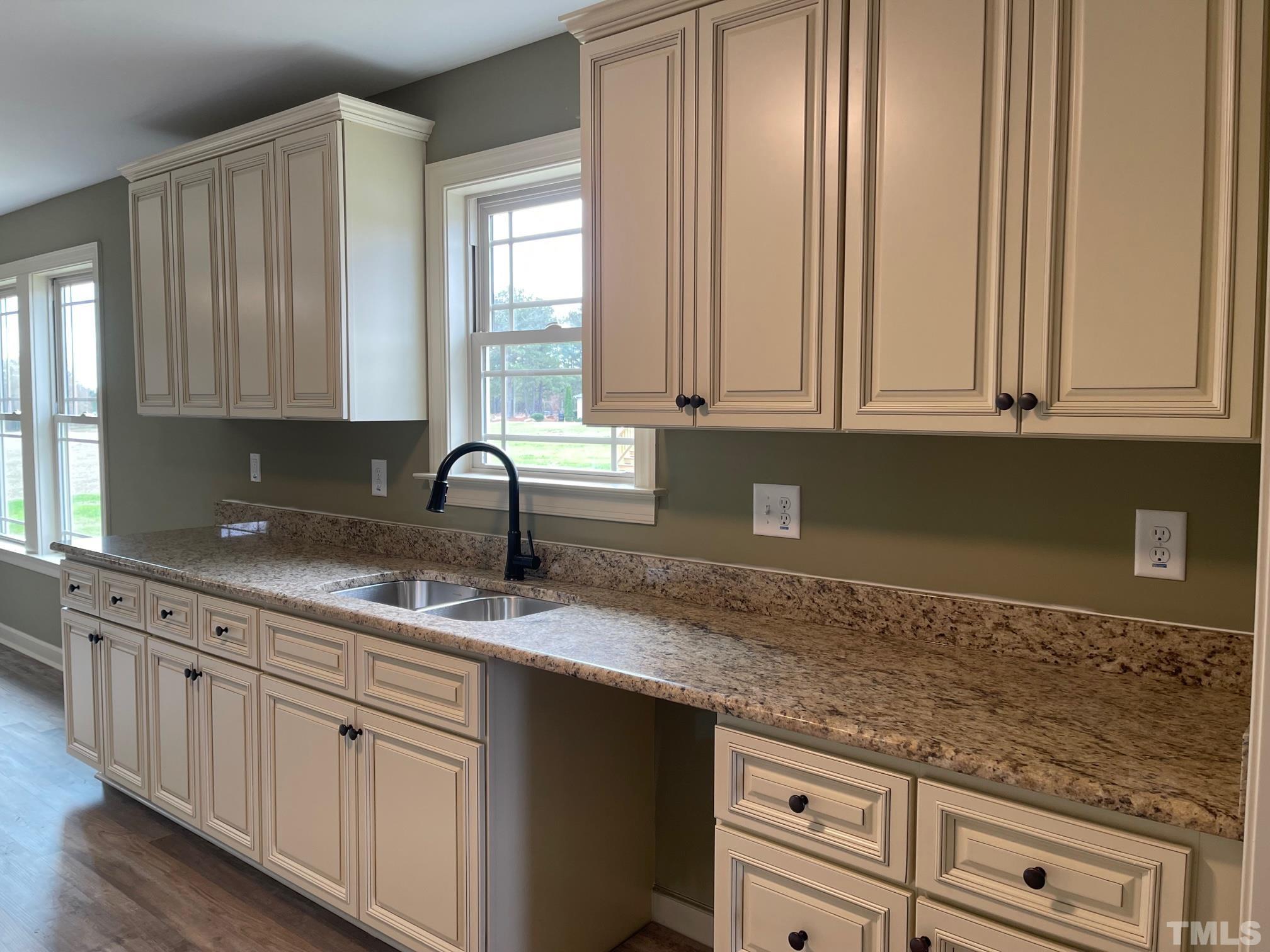 665 Bethel Church Road Angier, NC 27501 - Photo 6 of 32 a kitchen with granite countertop white cabinets and sink