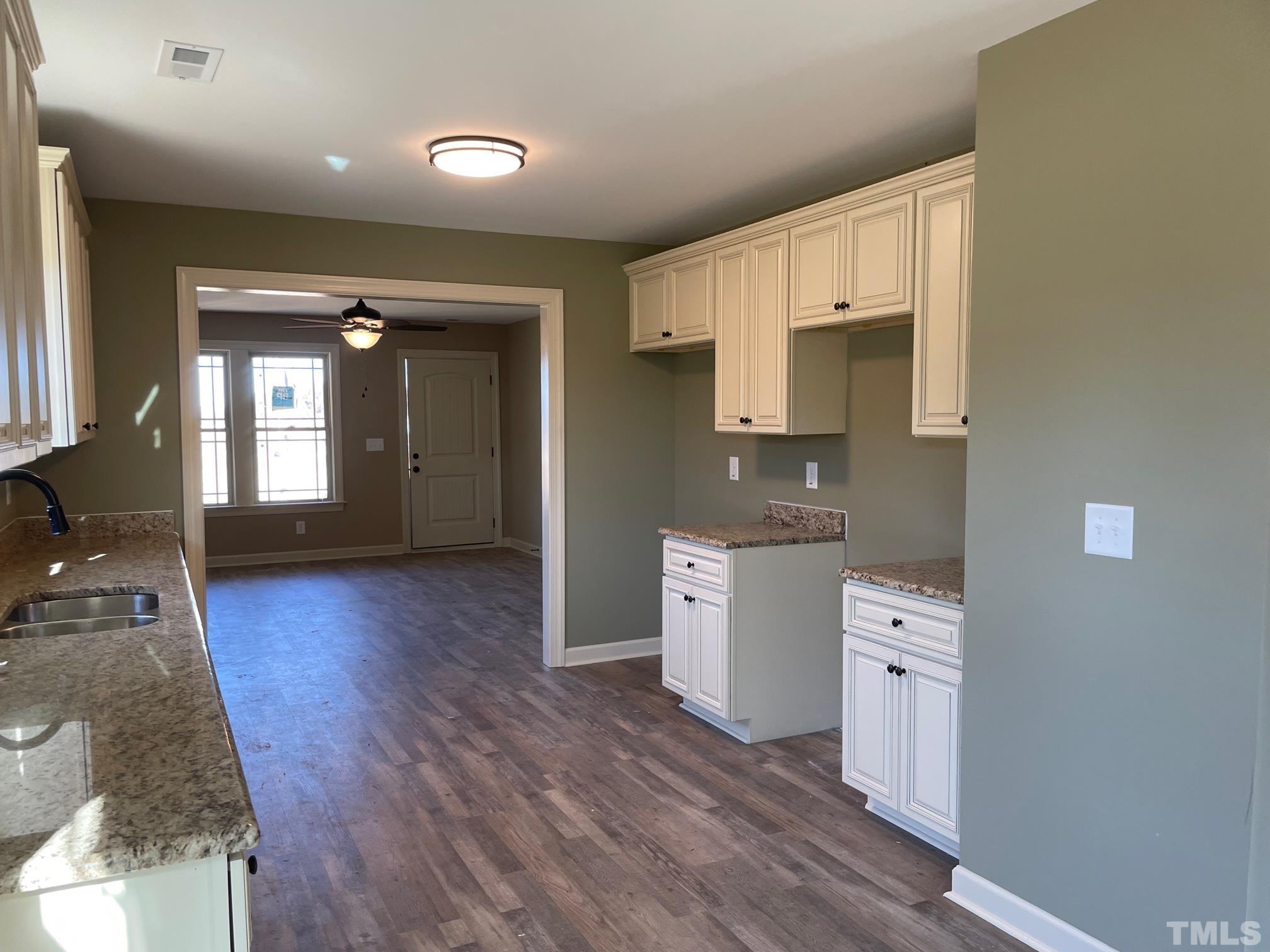 665 Bethel Church Road Angier, NC 27501 - Photo 7 of 32 a open kitchen with cabinets a sink and wooden floor