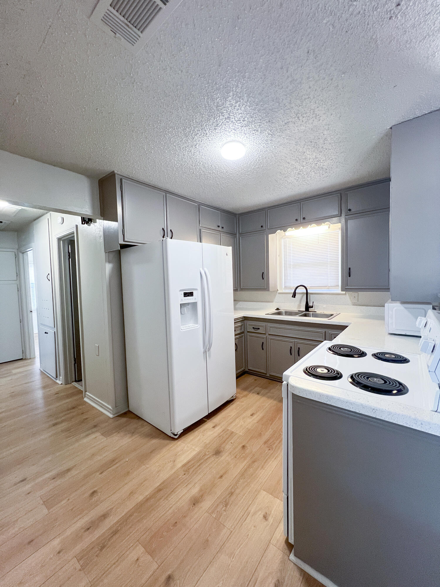 1513 37th Street Lubbock, TX 79412 - Photo 14 of 34 a kitchen with a refrigerator sink and cabinets