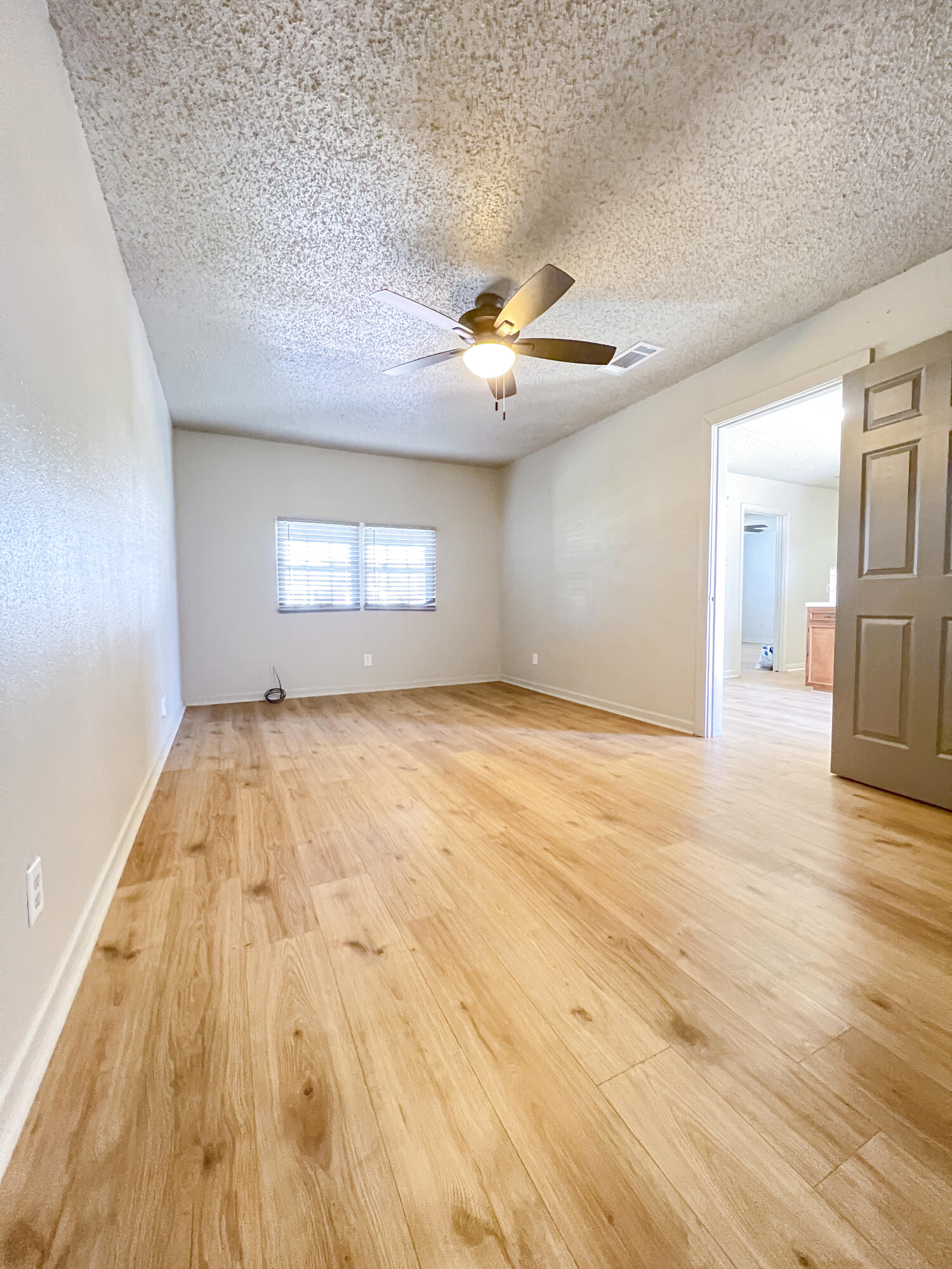 1513 37th Street Lubbock, TX 79412 - Photo 19 of 34 a view of empty room with wooden floor and fan