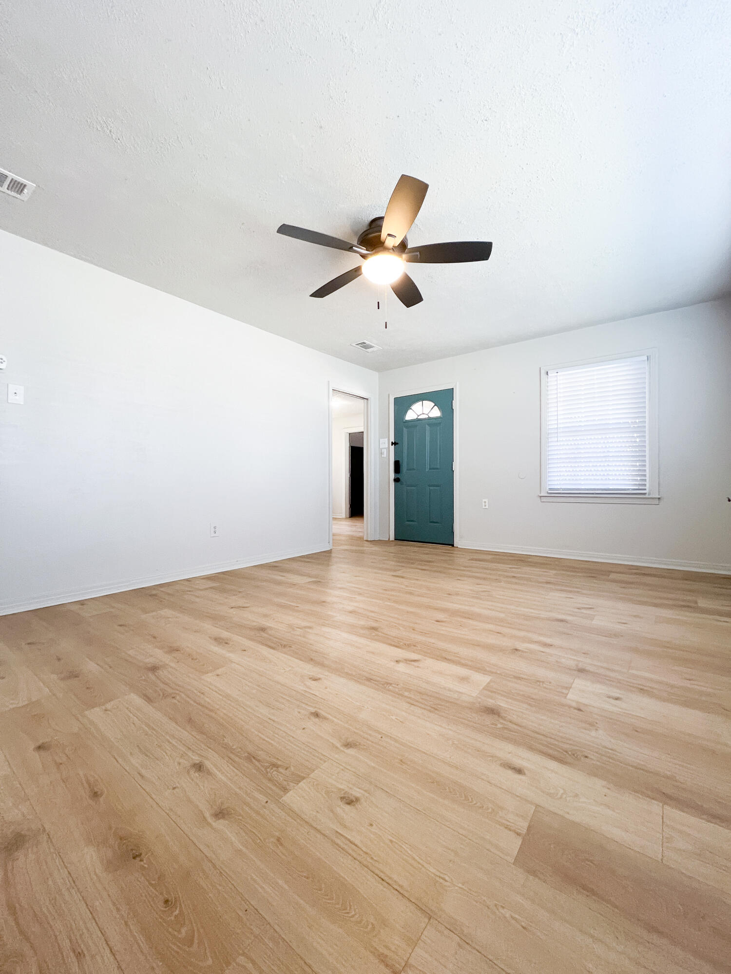 1513 37th Street Lubbock, TX 79412 - Photo 4 of 34 an empty room with chandelier fan and windows