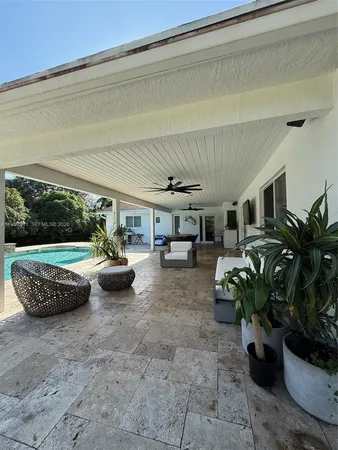 a view of a porch with furniture and a garden