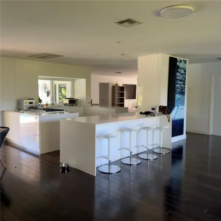a kitchen with granite countertop a stove a sink and a refrigerator