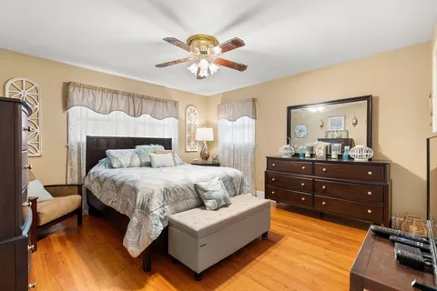 a bedroom with a bed and a mirror on the dresser